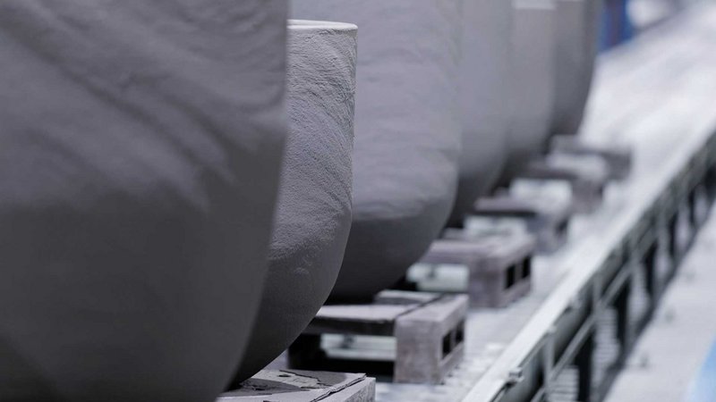 Close-up of FOSECO crucibles lined up in a storage facility – showcasing durable refractory solutions for efficient metal melting in non-ferrous foundry applications.